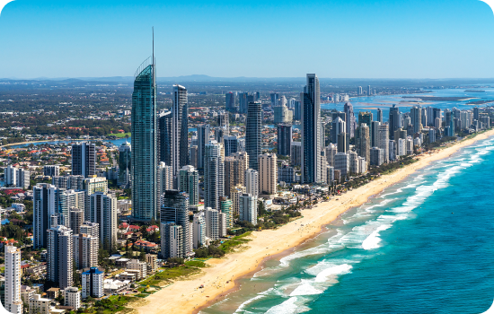 City skyline with high-rise buildings along golden beach front and blue ocean.
